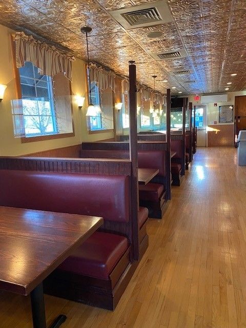 The inside of a restaurant with tables and booths