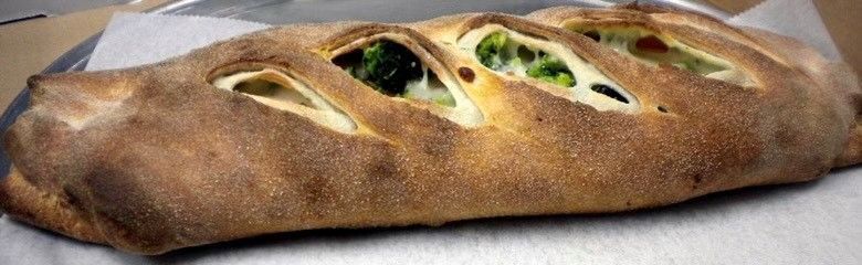 A close up of a pizza roll on a plate.