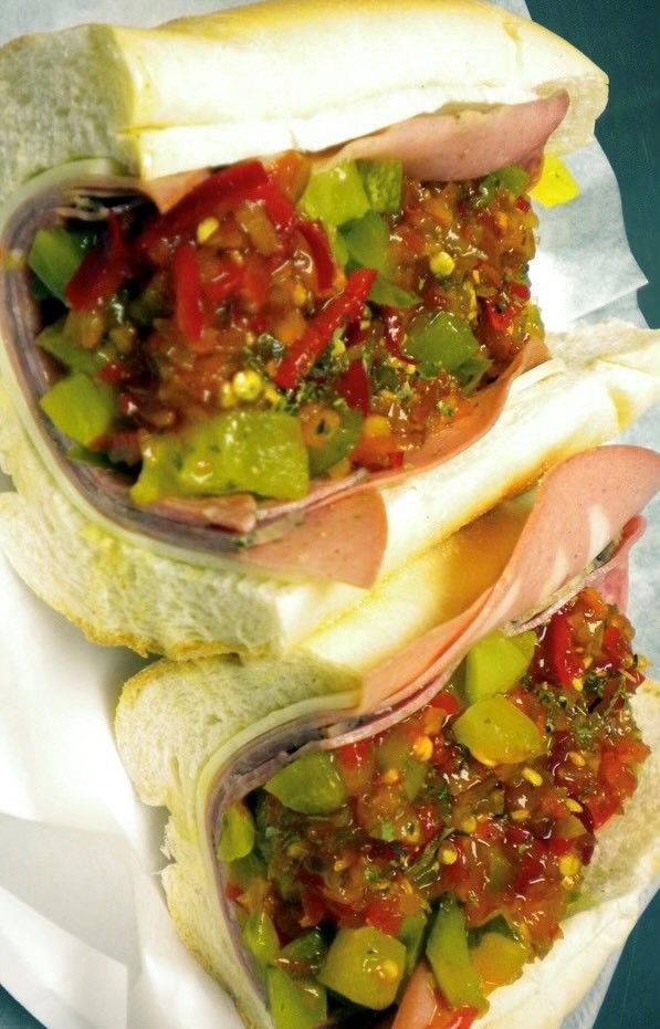 Two sandwiches are stacked on top of each other on a piece of paper