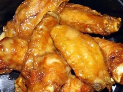 A close up of chicken wings on a black plate