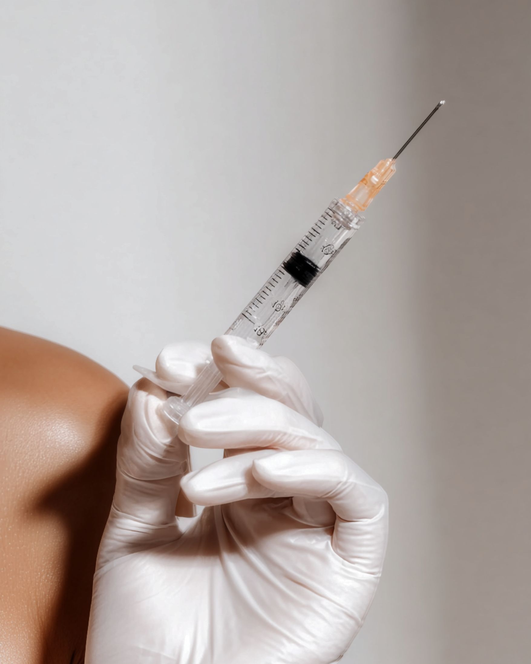Gloved hand holding a syringe