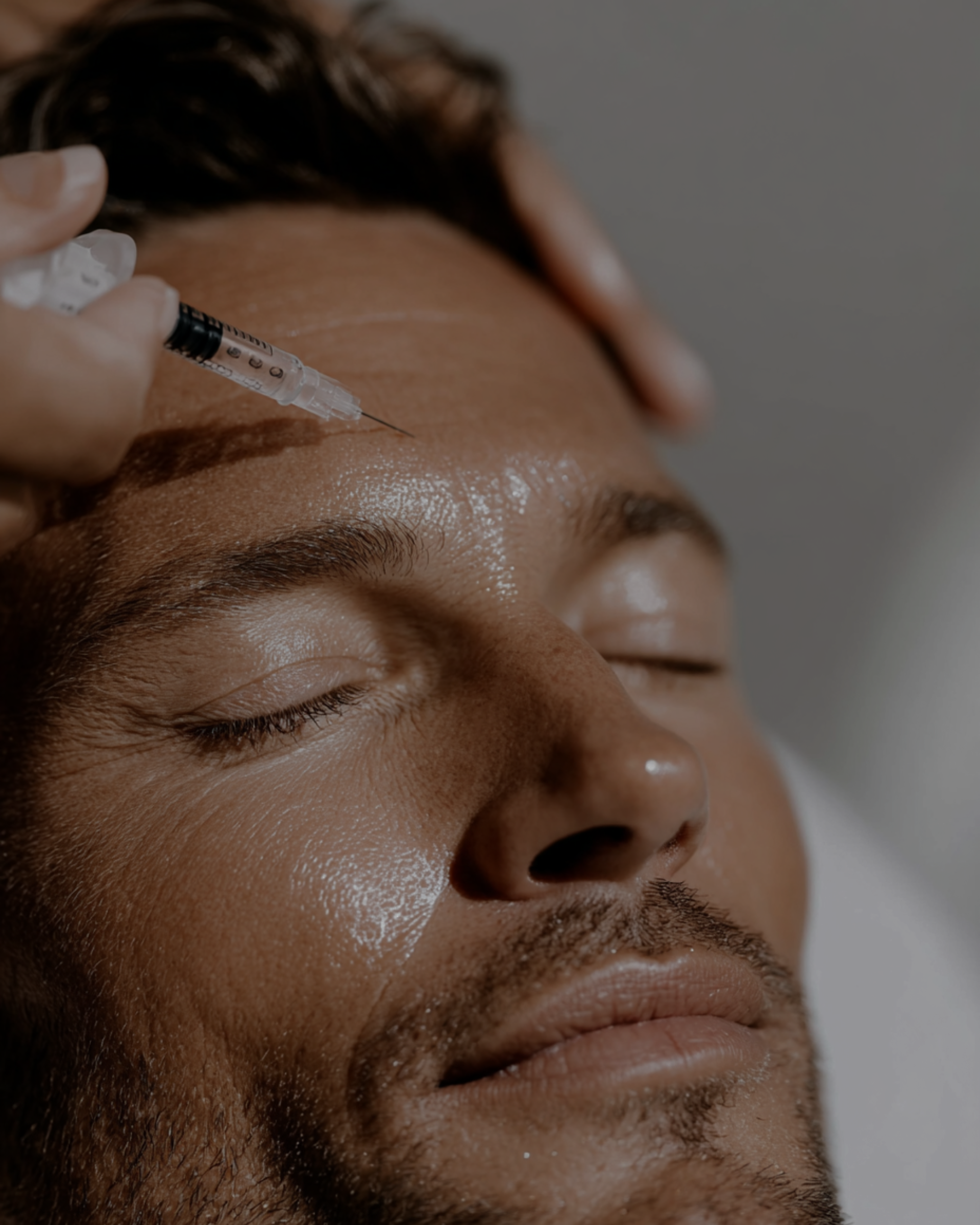 A person in white gloves administers a facial filler injection near a client's mouth in a clinical setting.