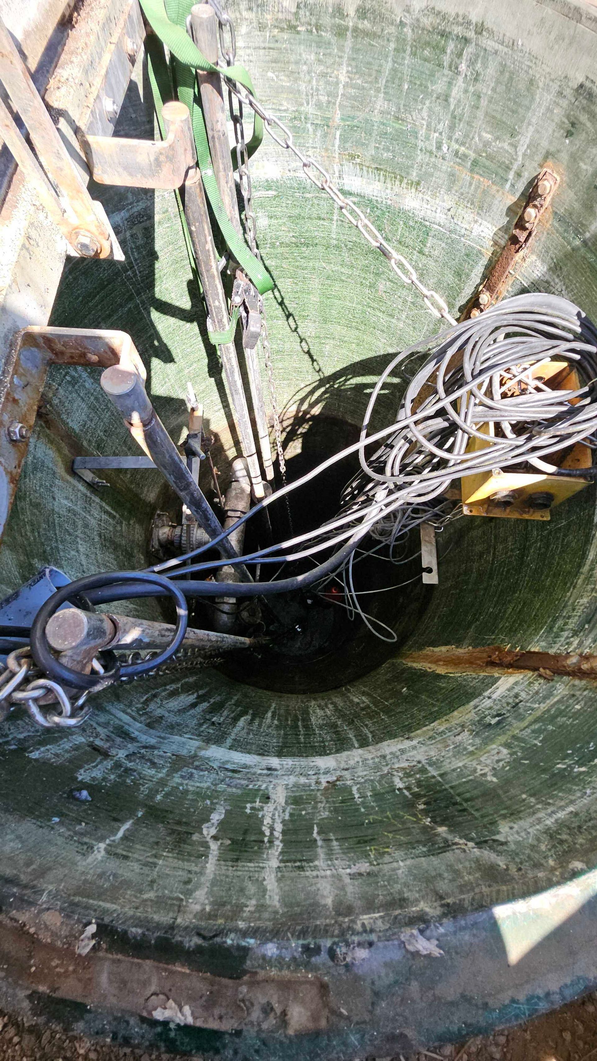 A bunch of wires are coming out of a hole in the ground.