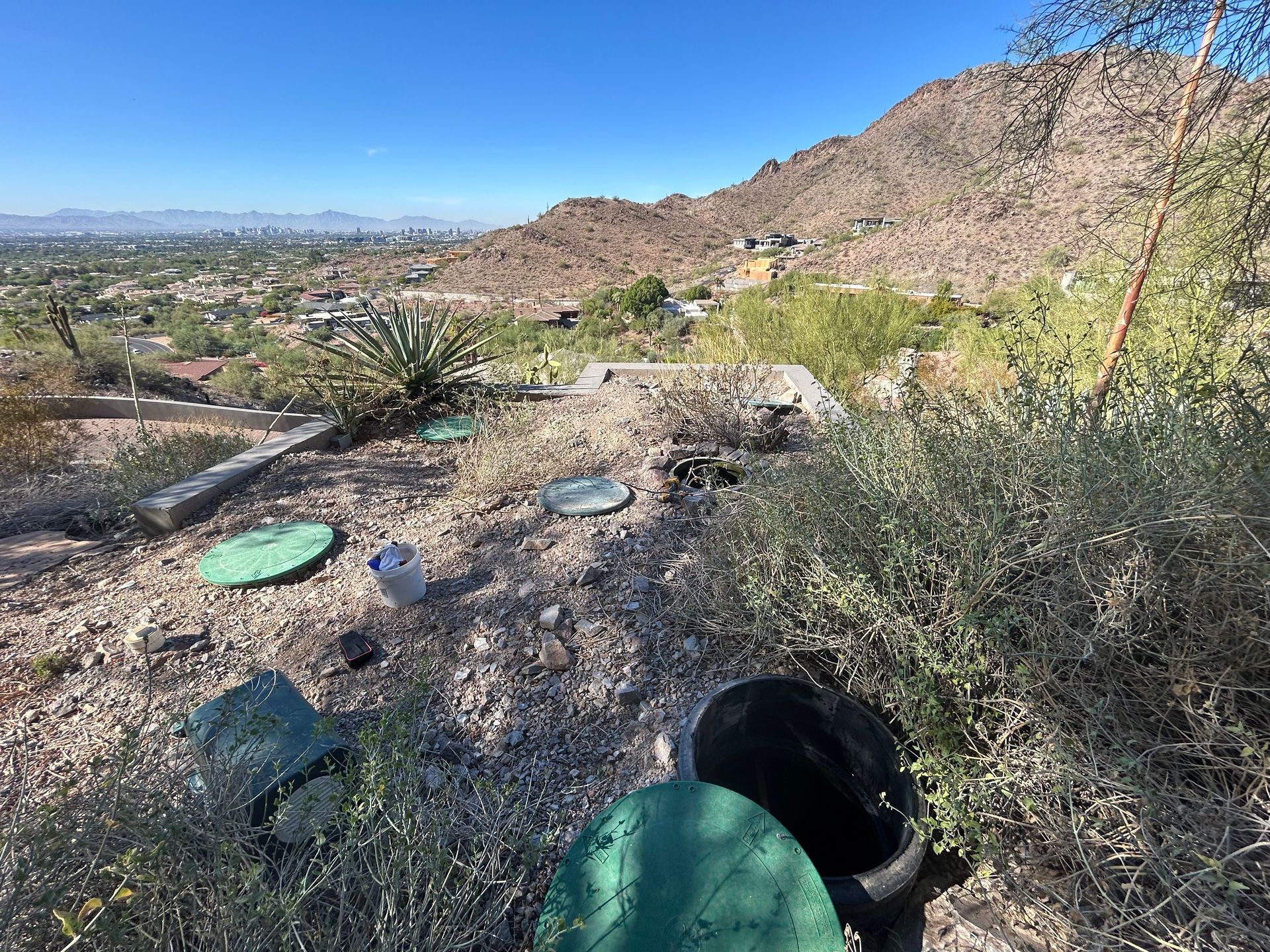 A dirt field with a view of a city and mountains in the background.
