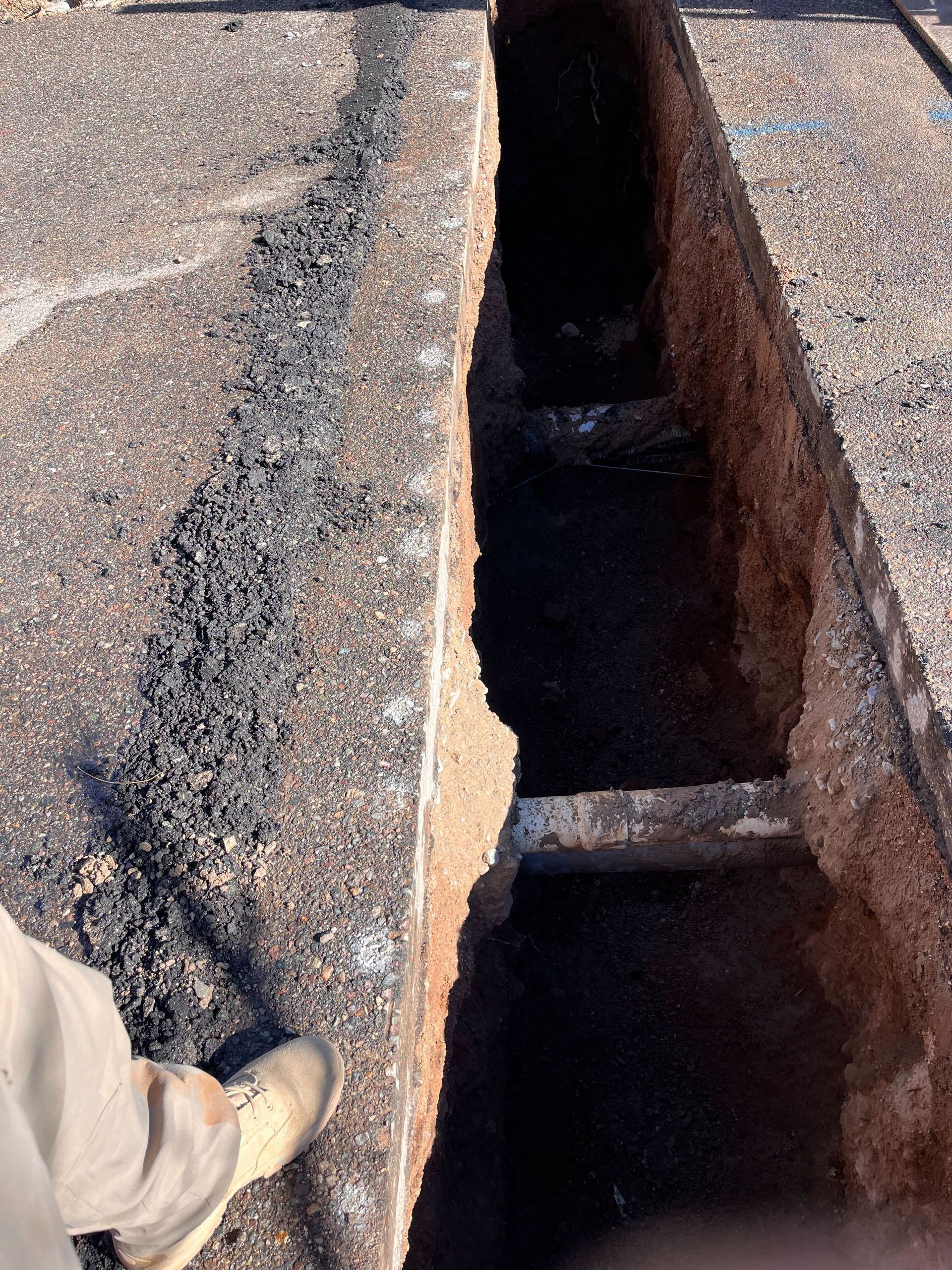 A person is standing next to a hole in the ground.