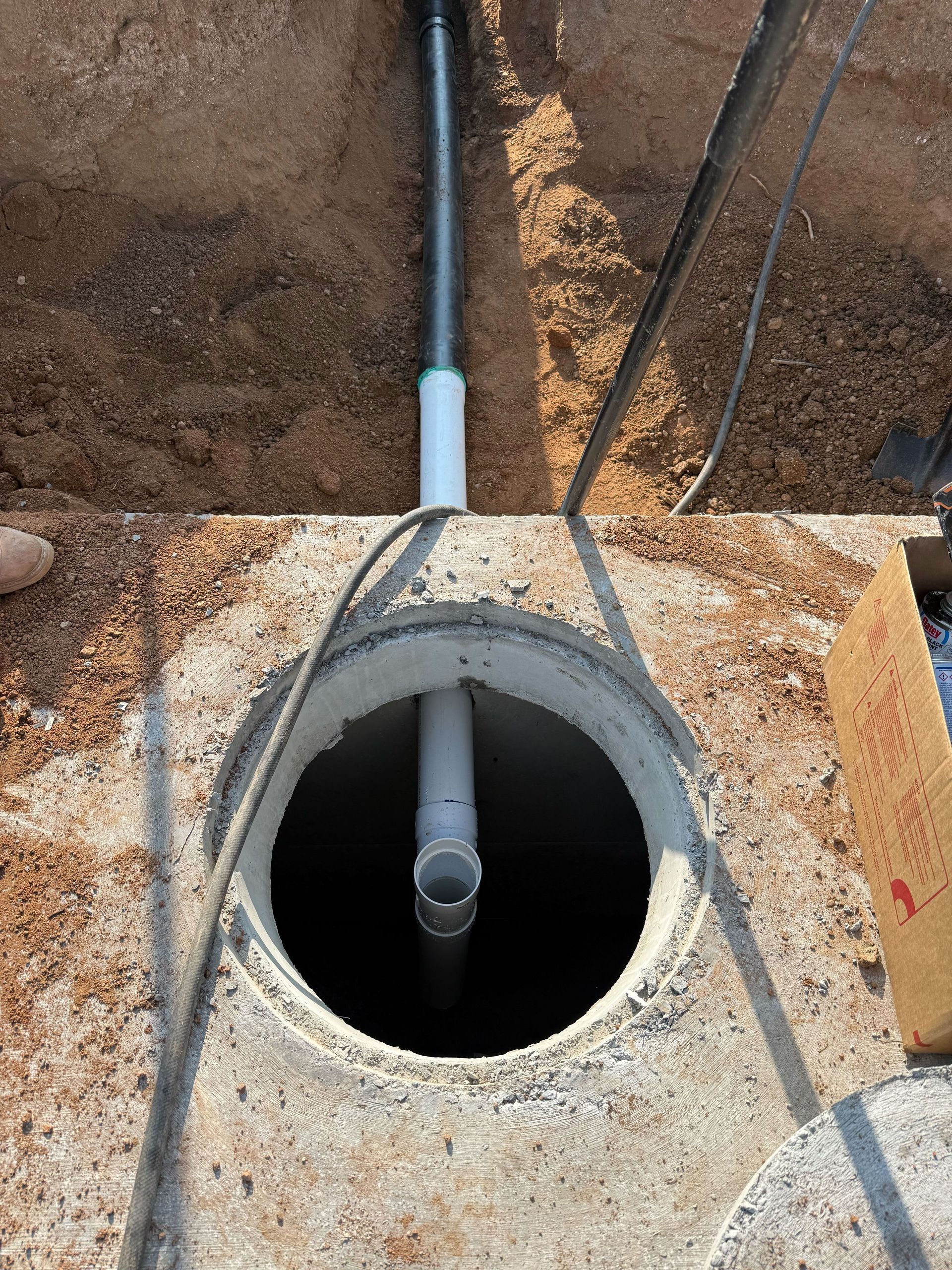 A pipe is coming out of a hole in the ground.
