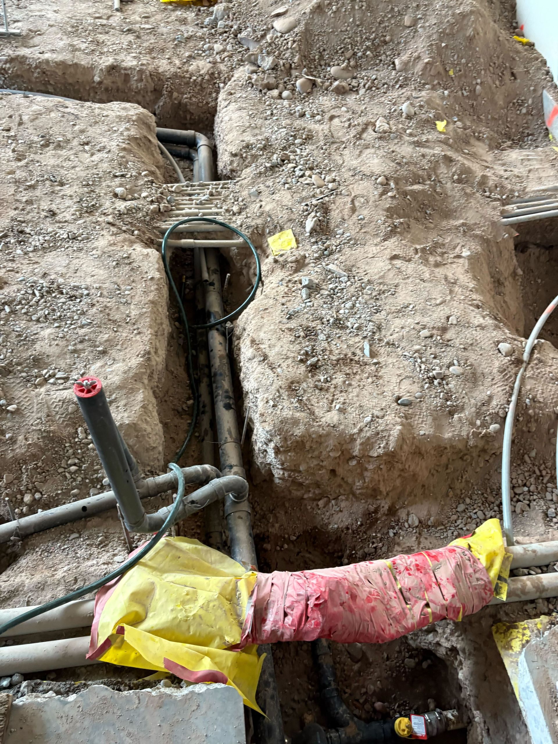 A bunch of wires are coming out of a hole in the ground.