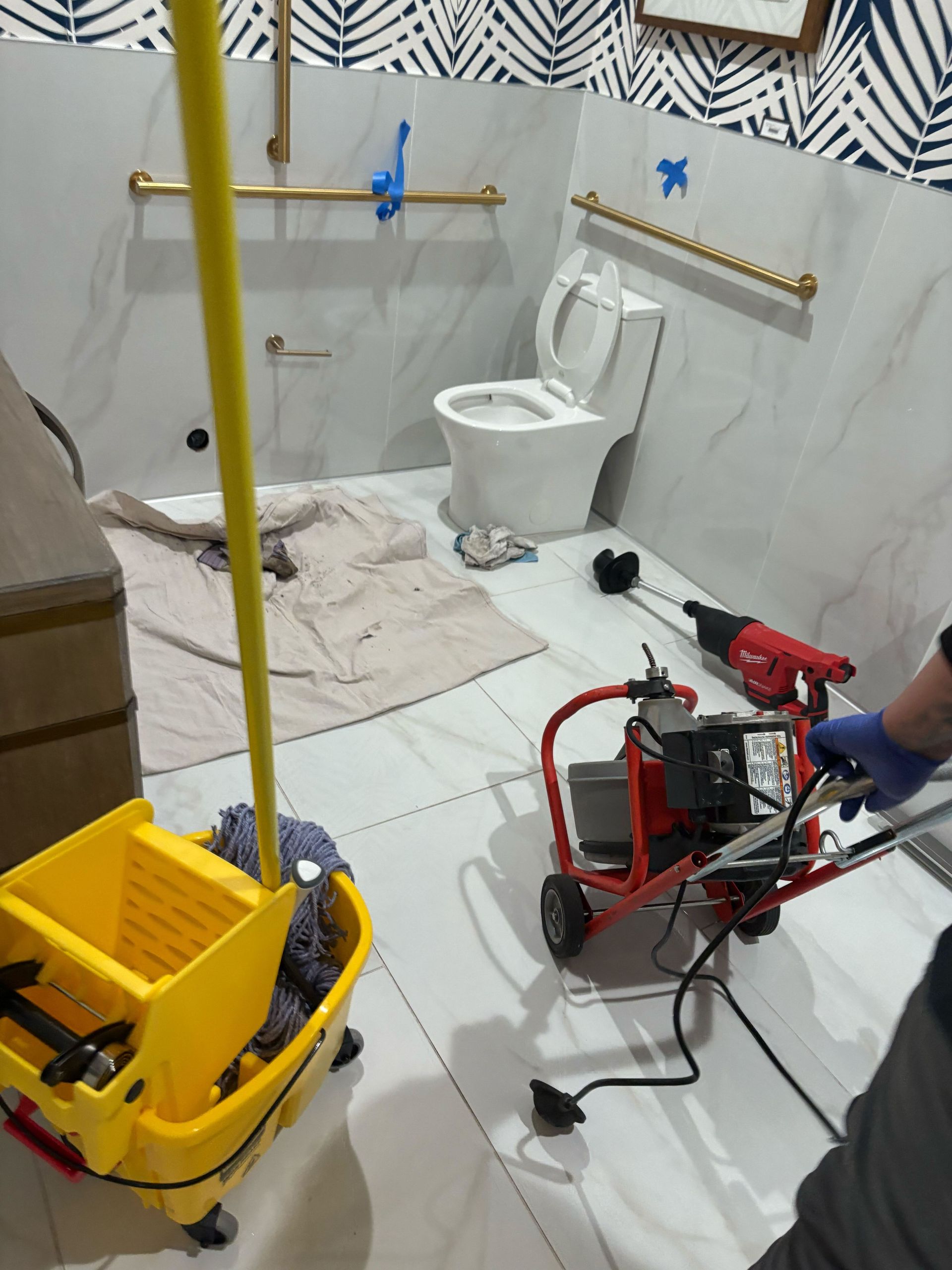 A man is working on a toilet in a bathroom