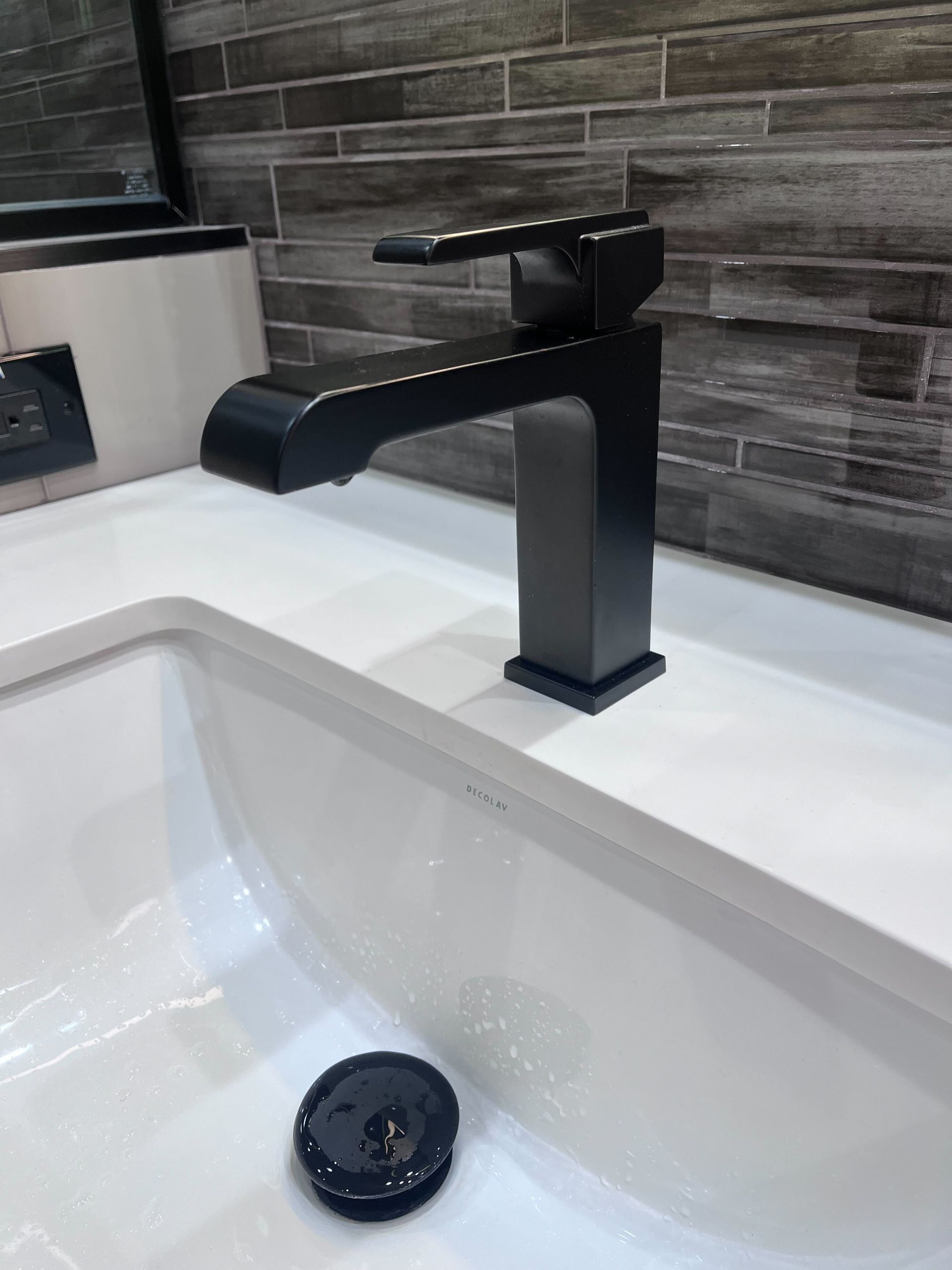 A black faucet is sitting on top of a white sink.