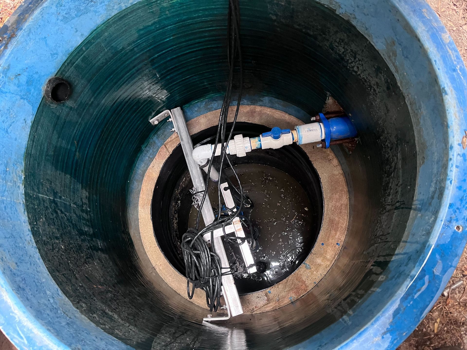 A blue barrel with a hose coming out of it.