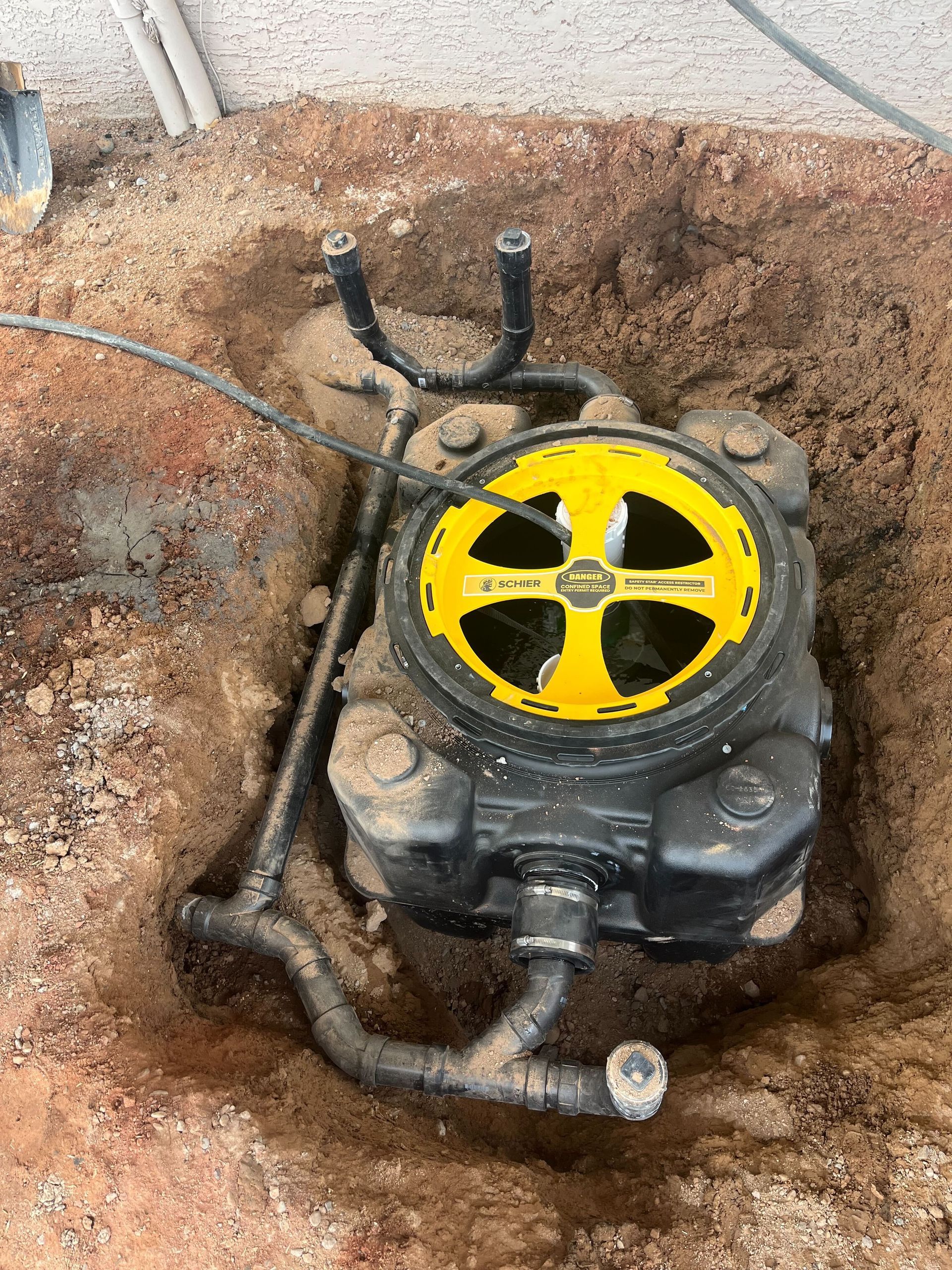 A black and yellow device is sitting in the dirt.