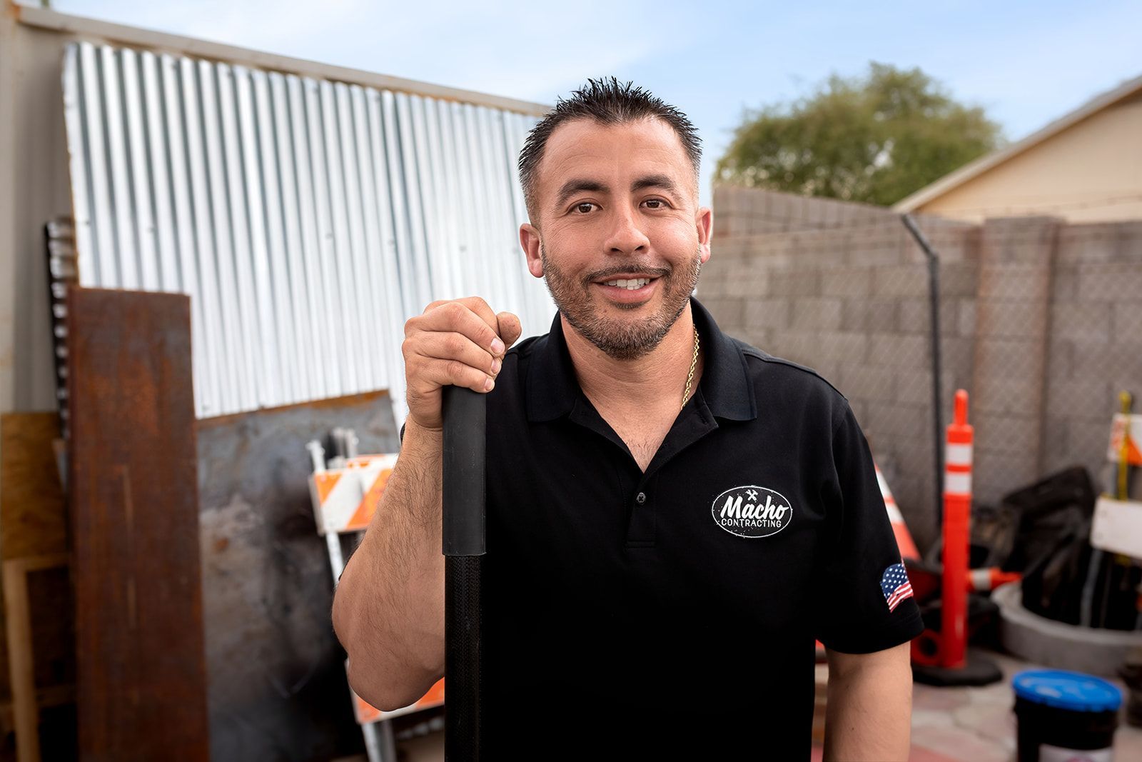 A man in a black shirt is holding a piece of metal in his hand.