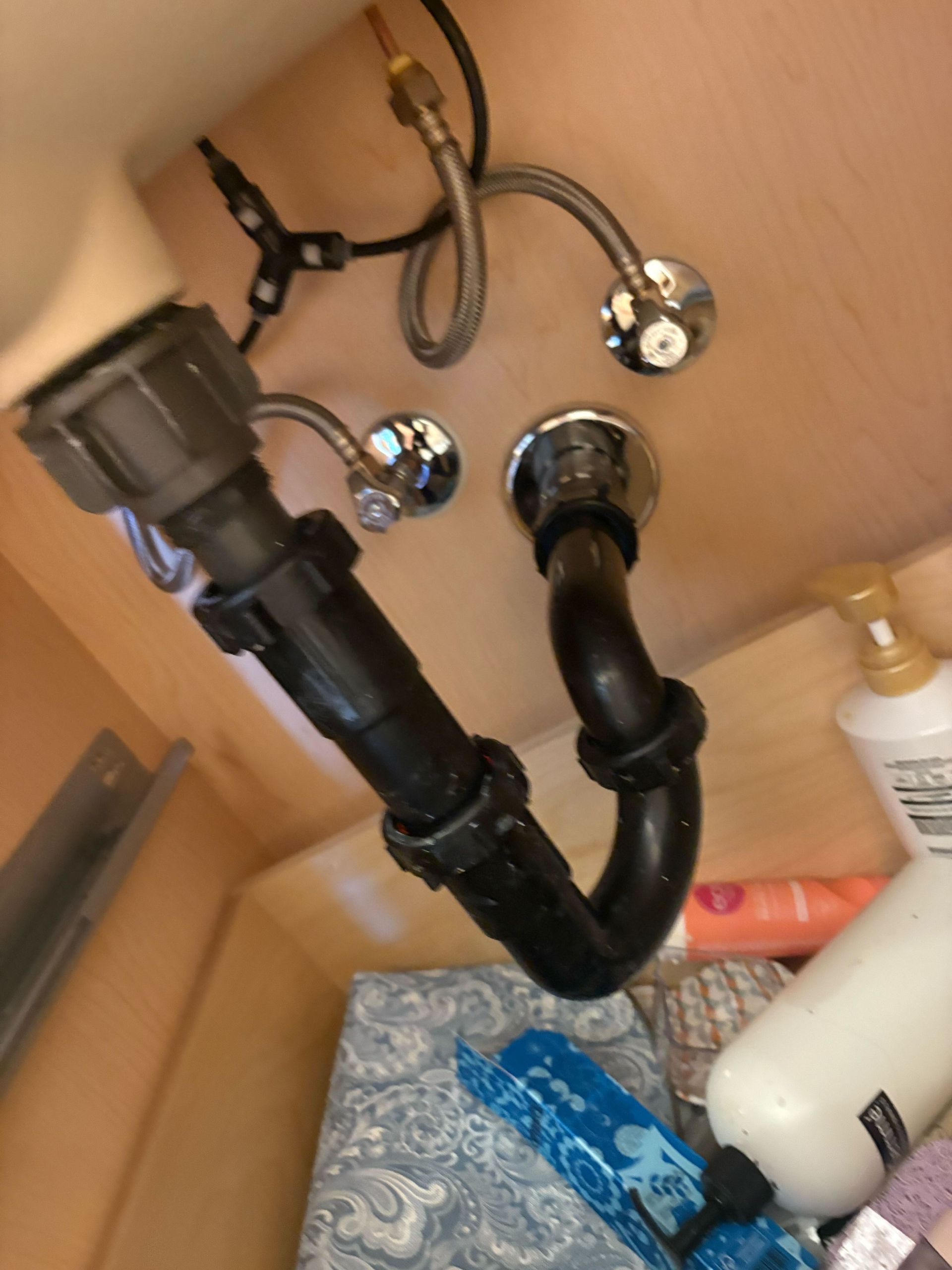 A bathroom sink with a black pipe underneath it