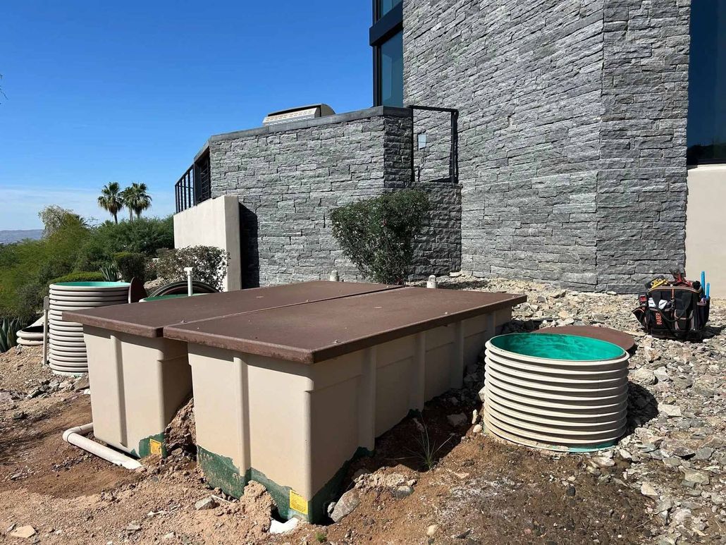 Outdoor septic tanks and circular water tanks near a building