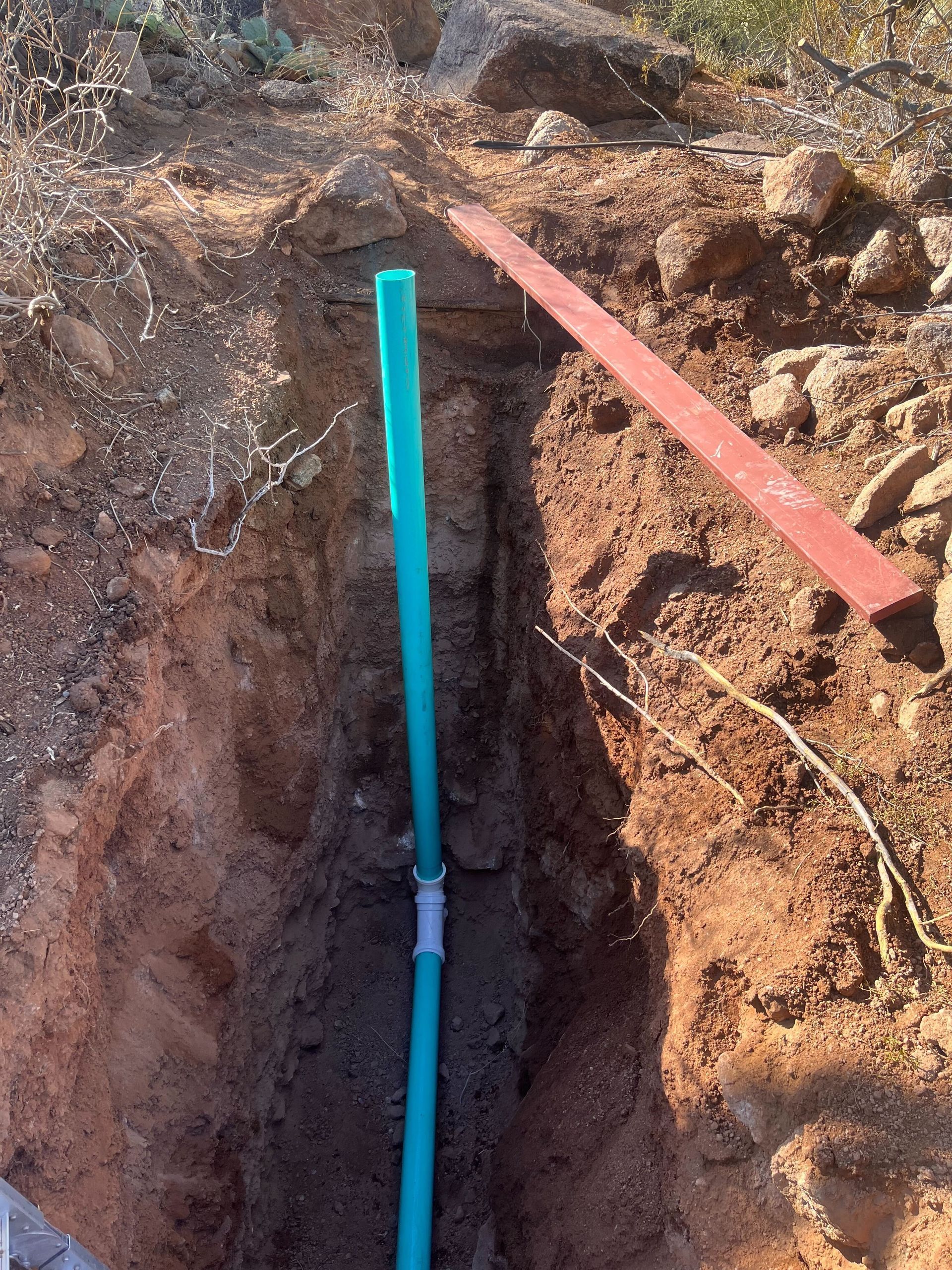 A blue pipe is sticking out of a hole in the ground.