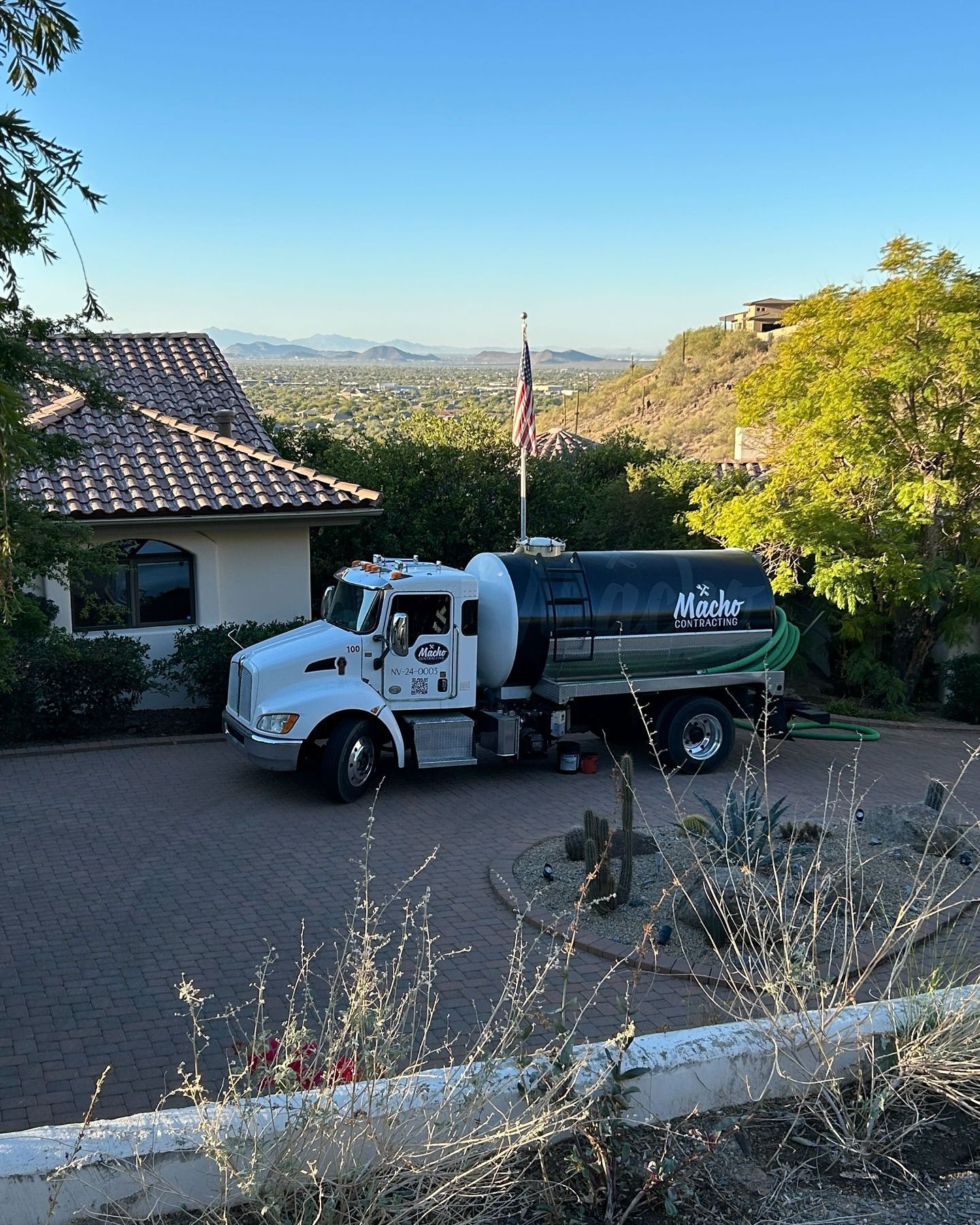A septic tank truck is parked in front of a house.