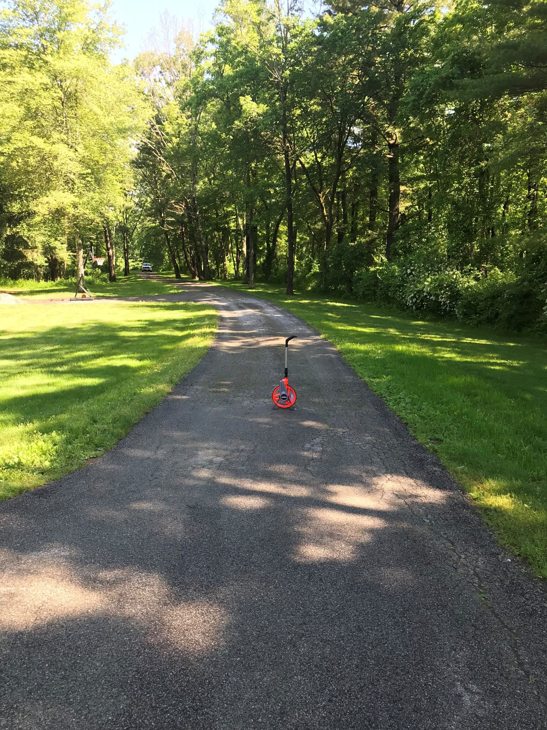 A scooter is sitting on the side of a dirt road.