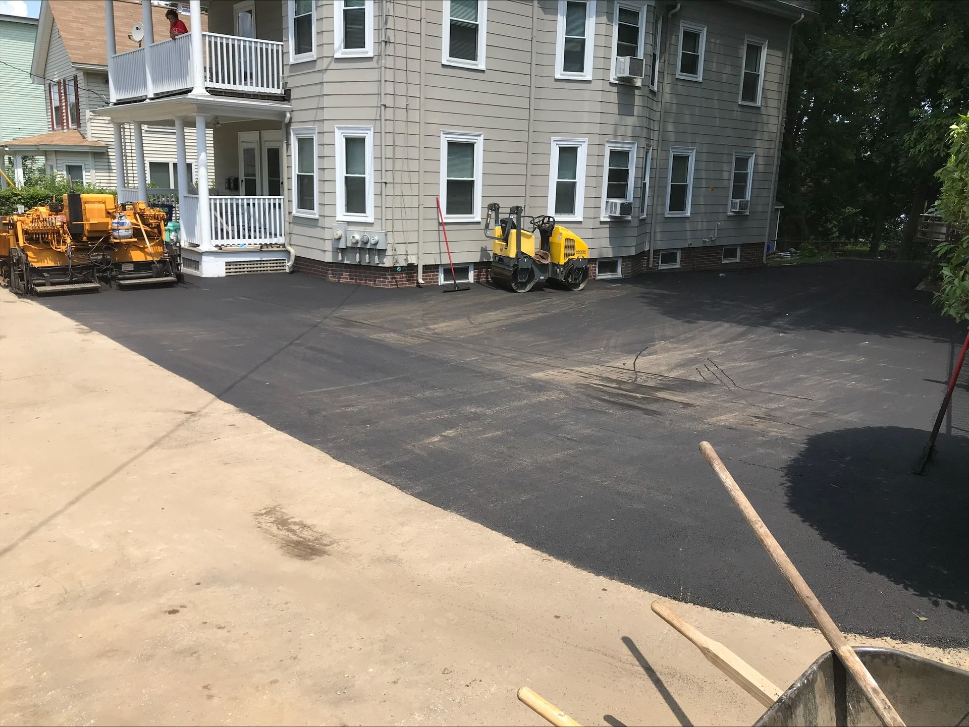 A large house with a large driveway being paved in front of it.
