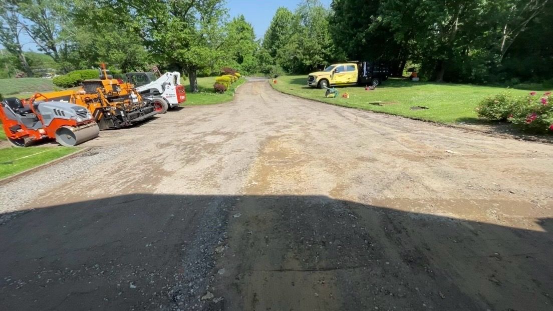 A group of trucks are parked on the side of a dirt road.