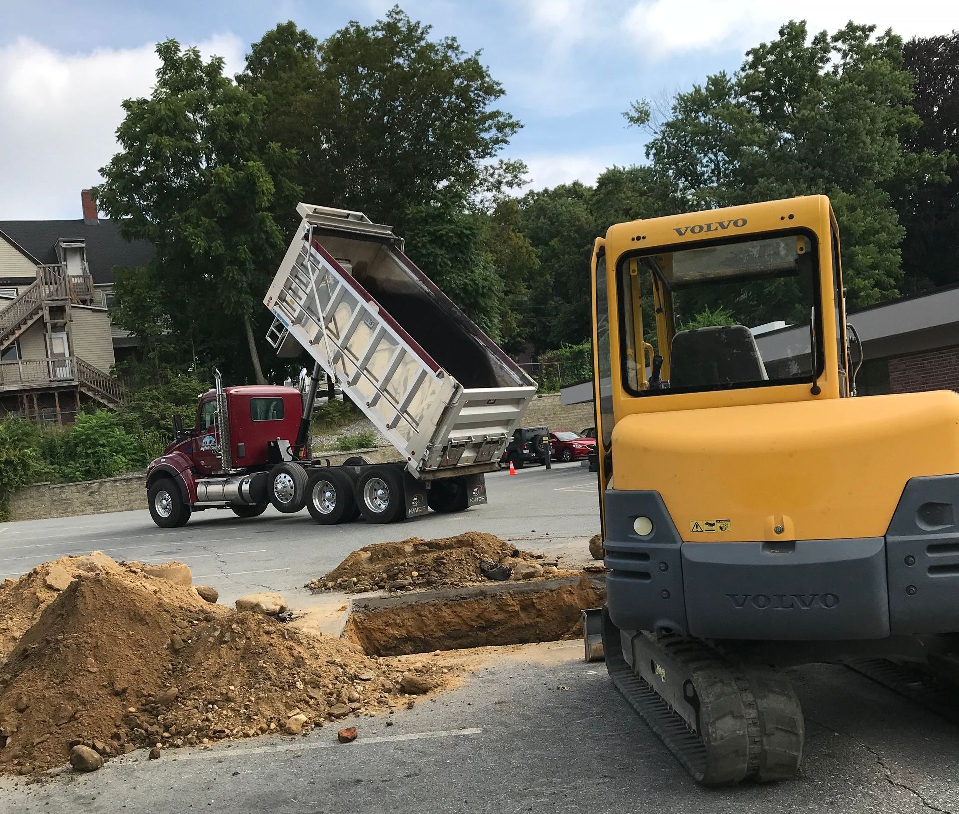 A Volvo dump truck is being loaded with dirt