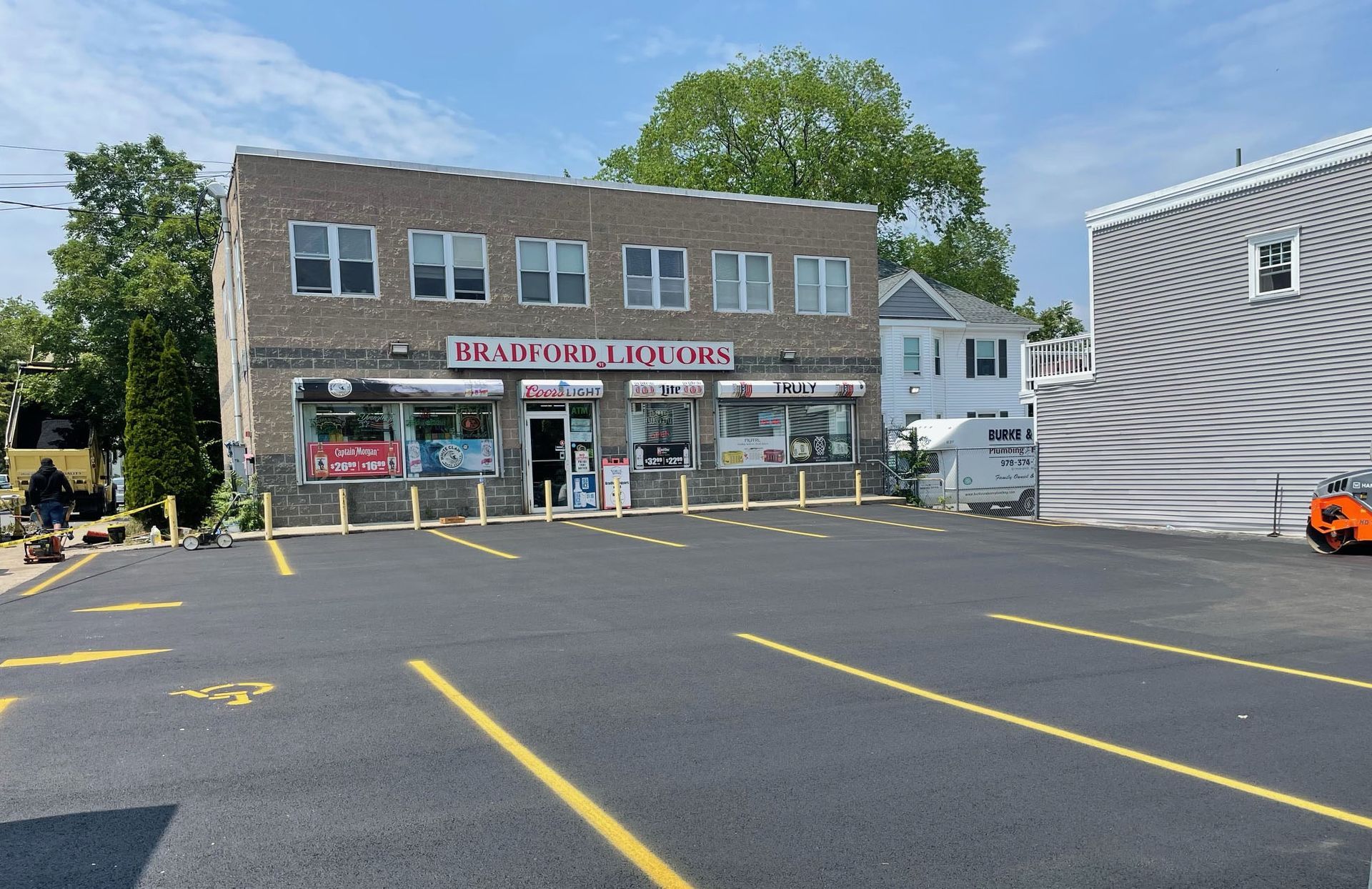 A parking lot in front of a brick building with a red sign that says ' emerald hillside ' on it