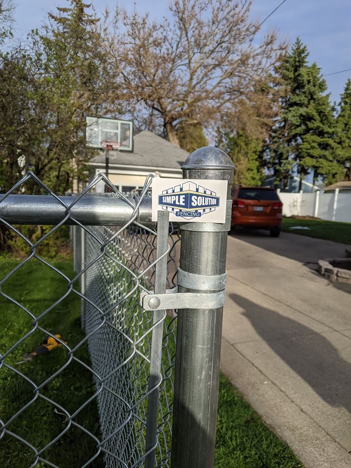 Chain-link fence post with a sign for 