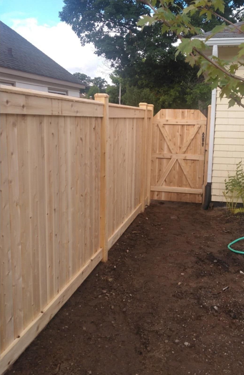 Wooden fence with matching gate in a backyard. Earth-toned colors.