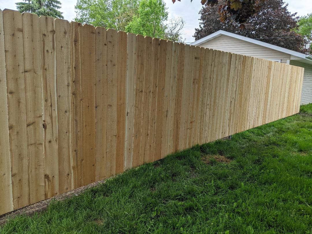 Wooden privacy fence in a grassy yard.