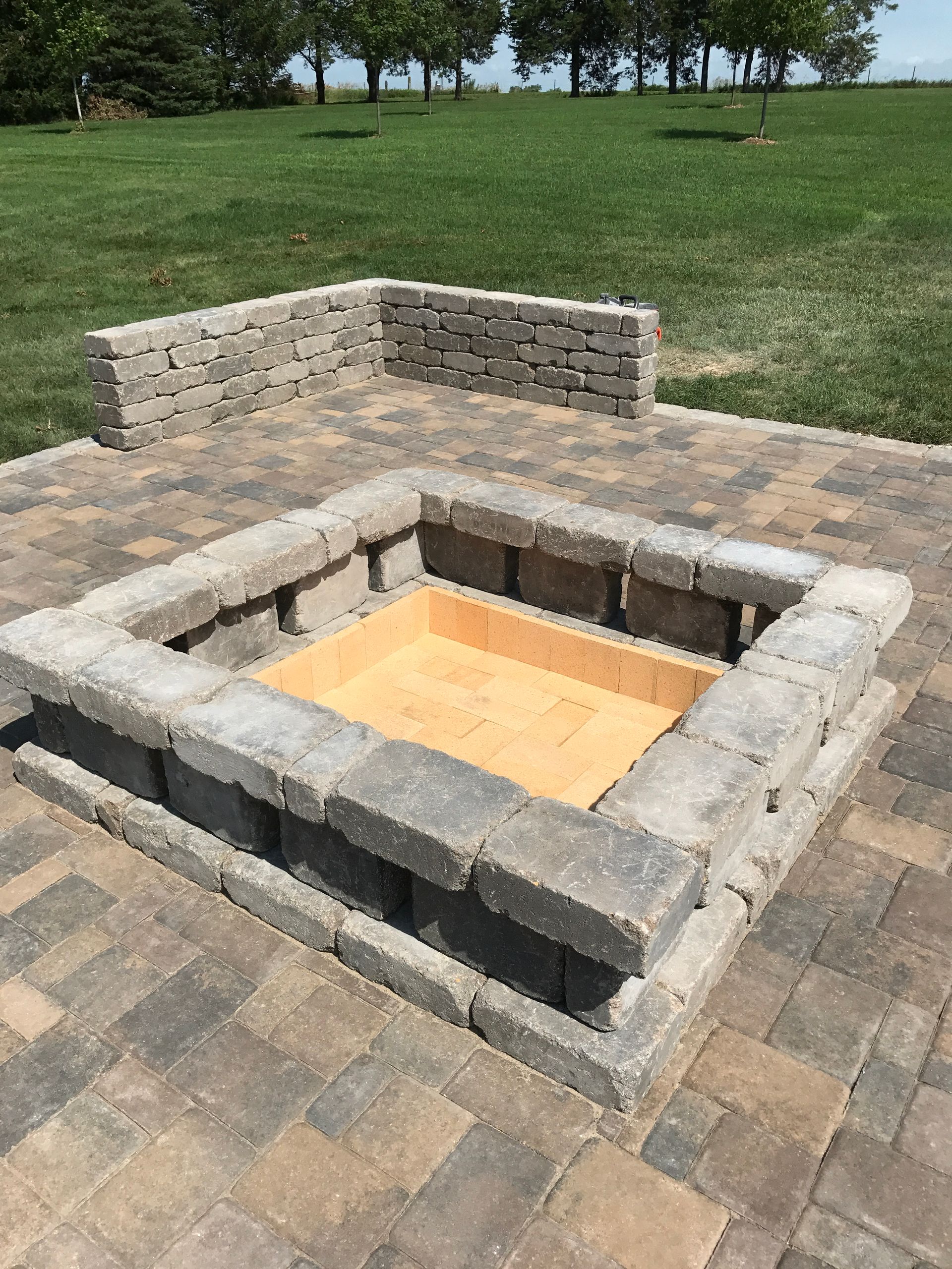 A fire pit is sitting on top of a brick patio.