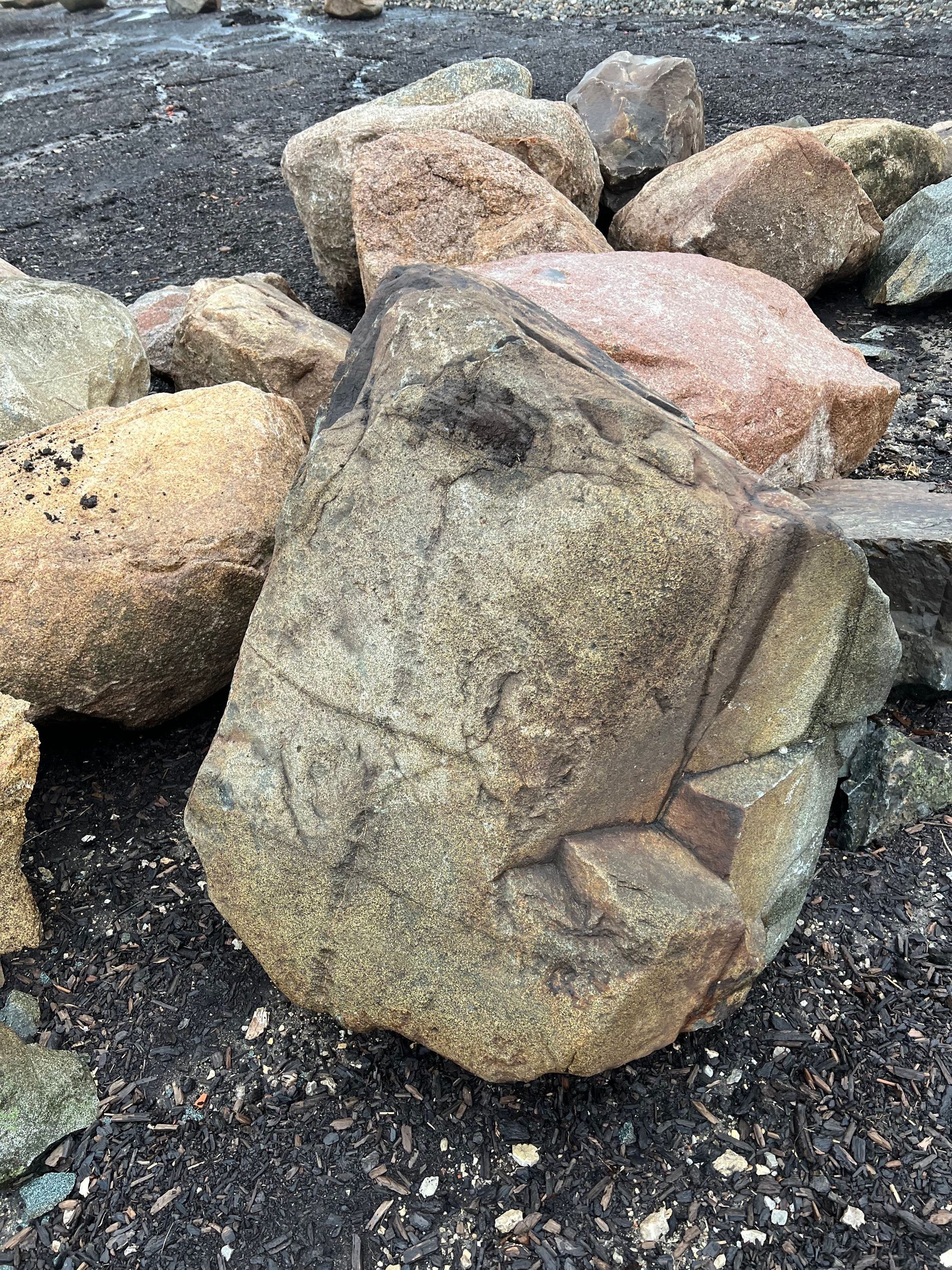 A pile of rocks sitting on top of each other on the ground.