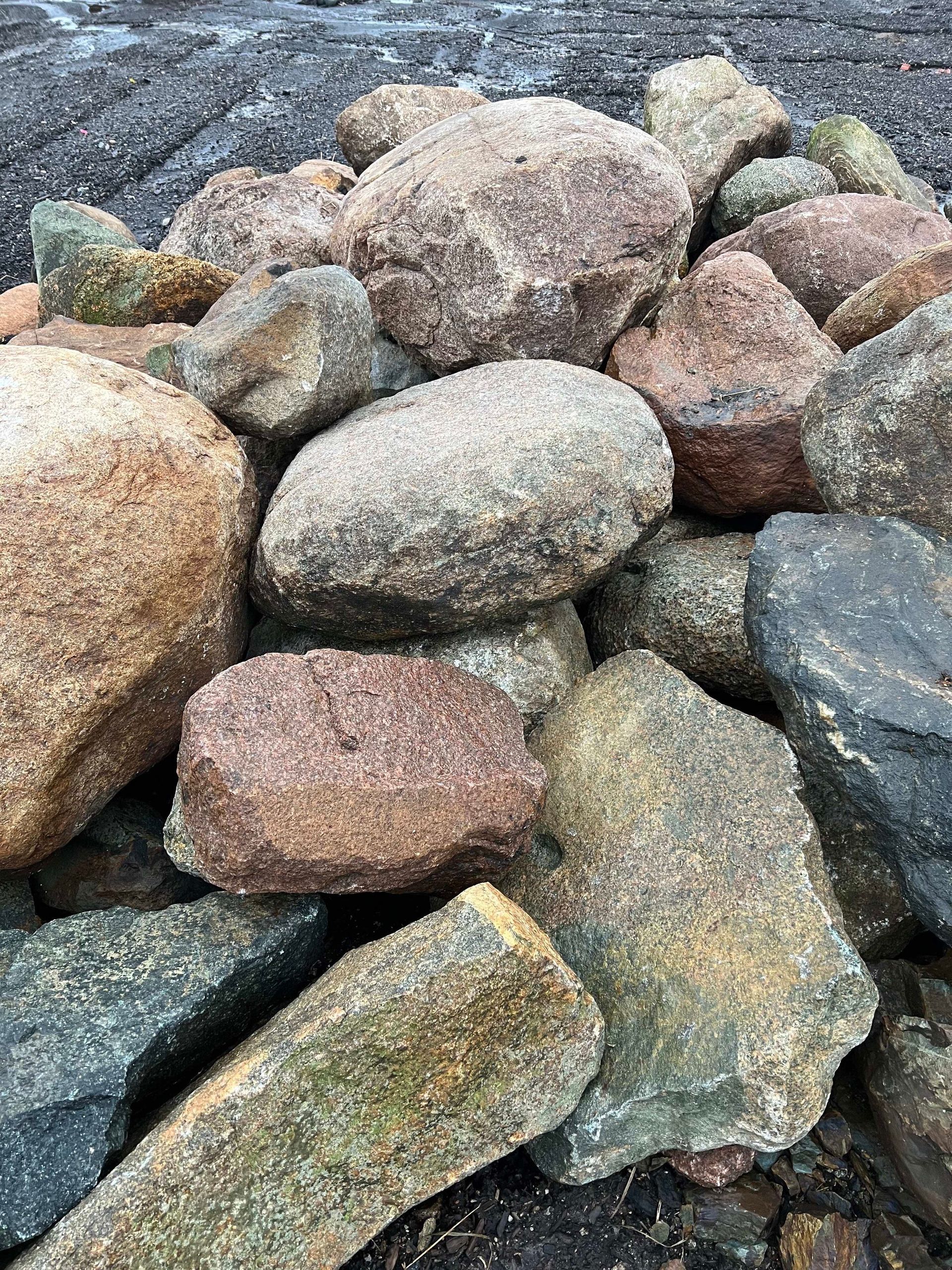A pile of rocks sitting on top of each other on the ground.