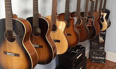 Different acoustic guitars hung on store