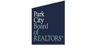 Park City Board of REALTORS logo in white text on a dark blue angled rectangle.