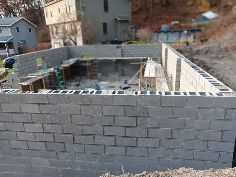 Concrete block foundation of a building under construction, gray blocks, outdoors.