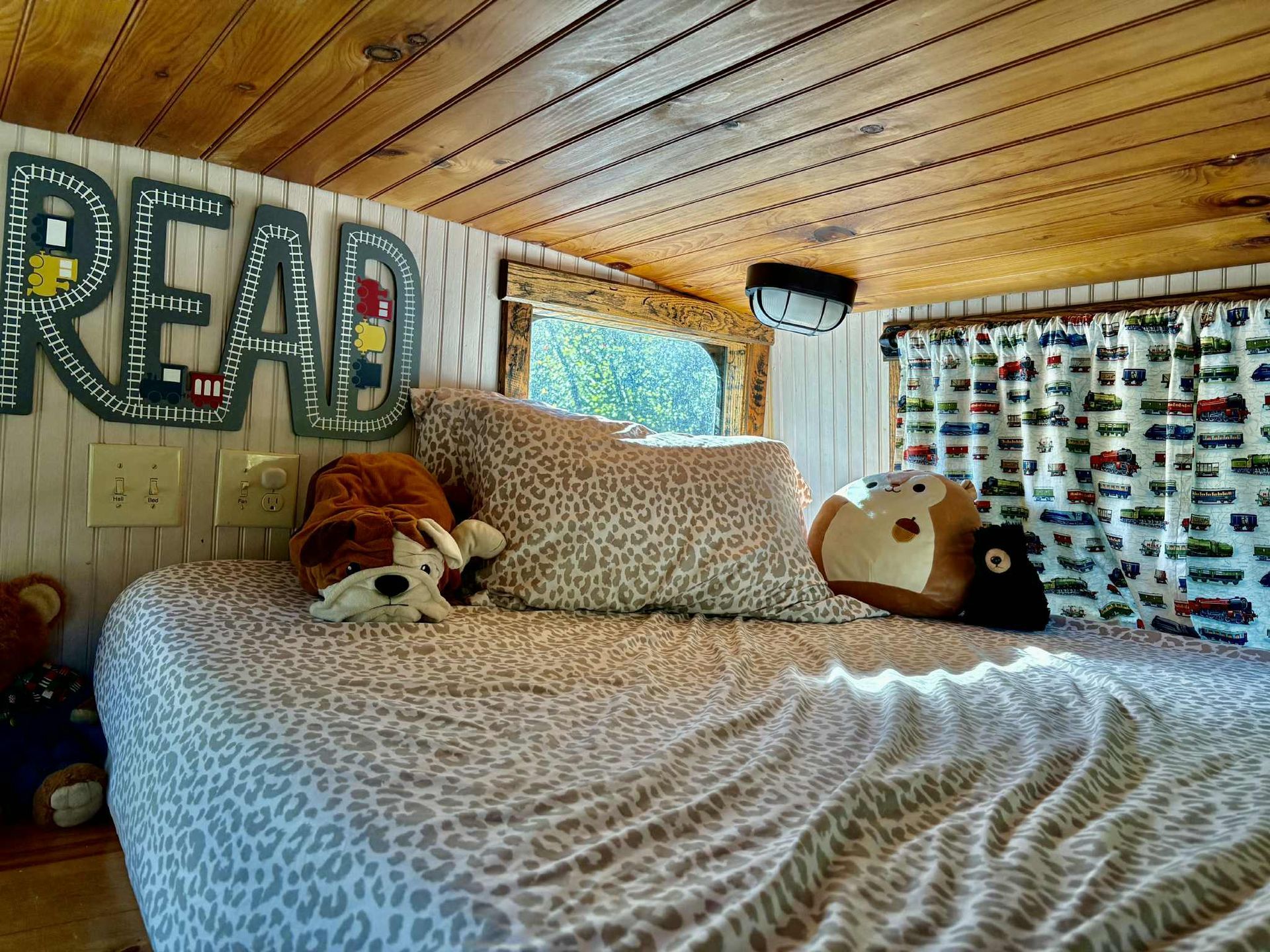 Cozy bed with animal print bedding, stuffed animals, and