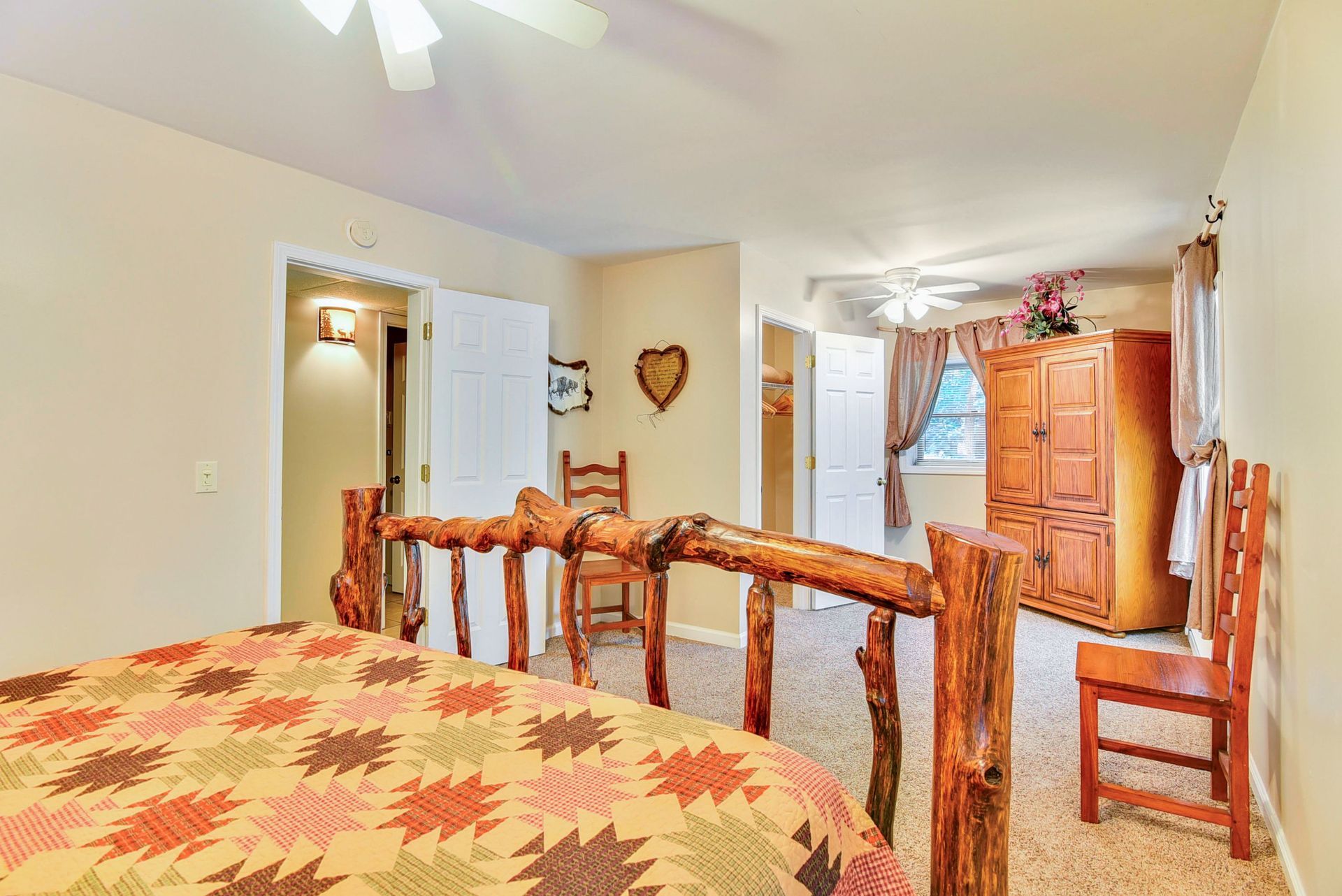 Bedroom with rustic wood bed frame, beige walls, and brown rug.