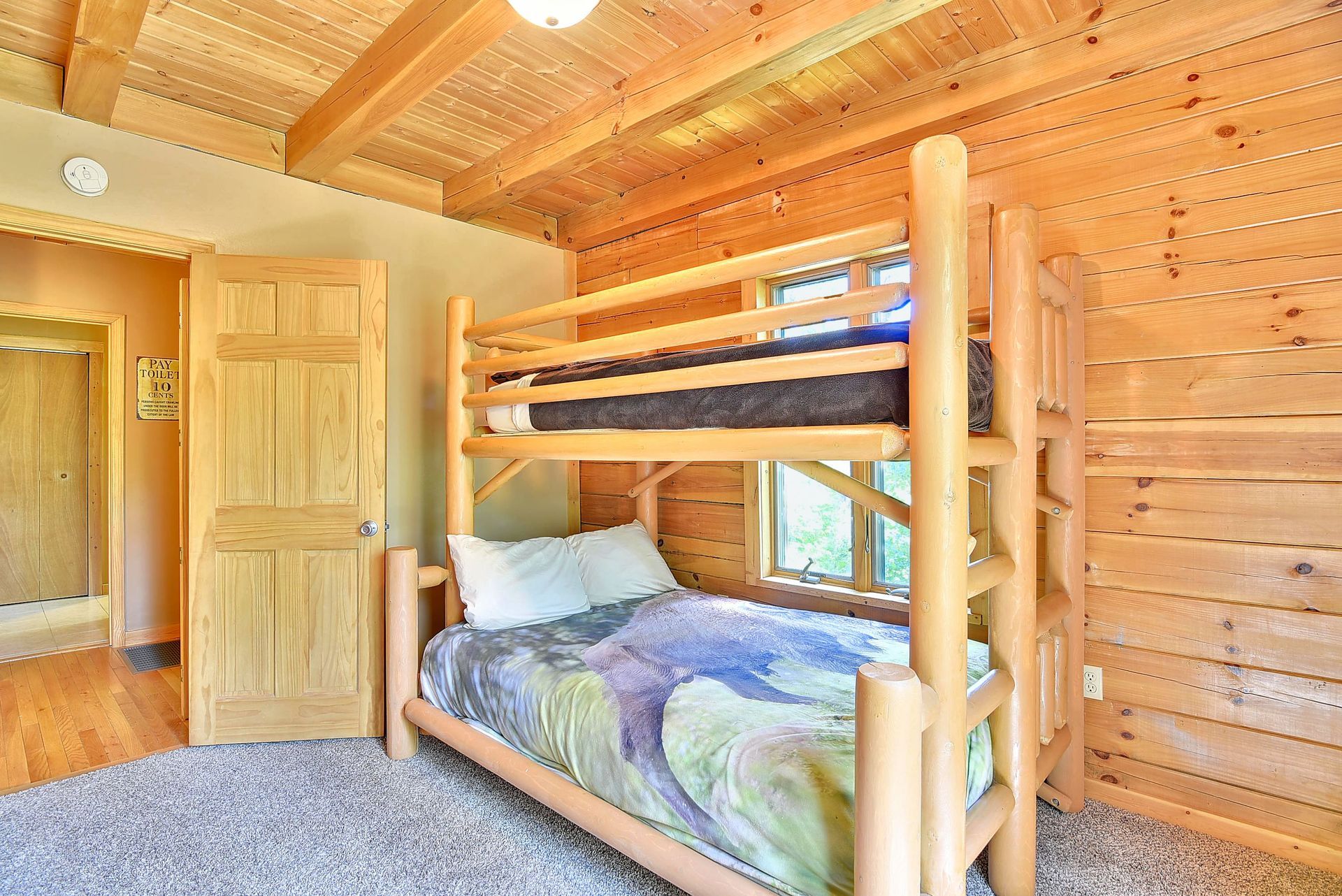 Bunk beds in a cabin-style room with wood paneling. The upper bunk is empty.