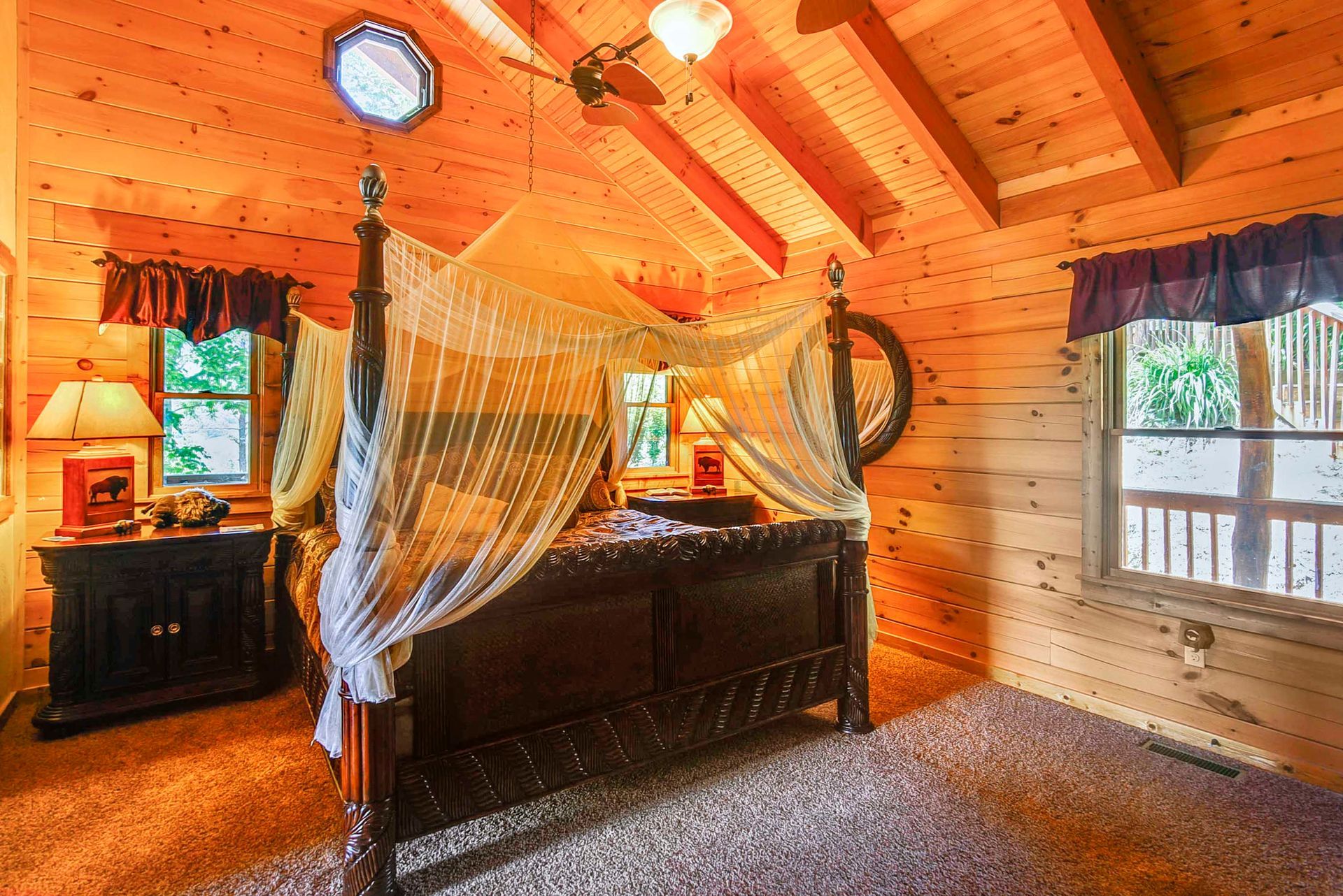 Wooden bedroom with four-poster bed, windows, and orange walls and ceiling.