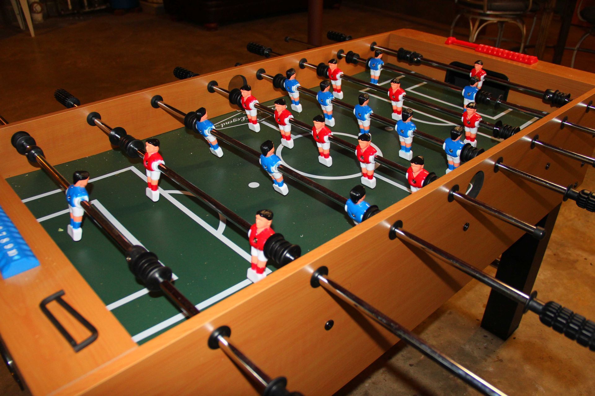 Foosball table with red and blue players, ready for a game.
