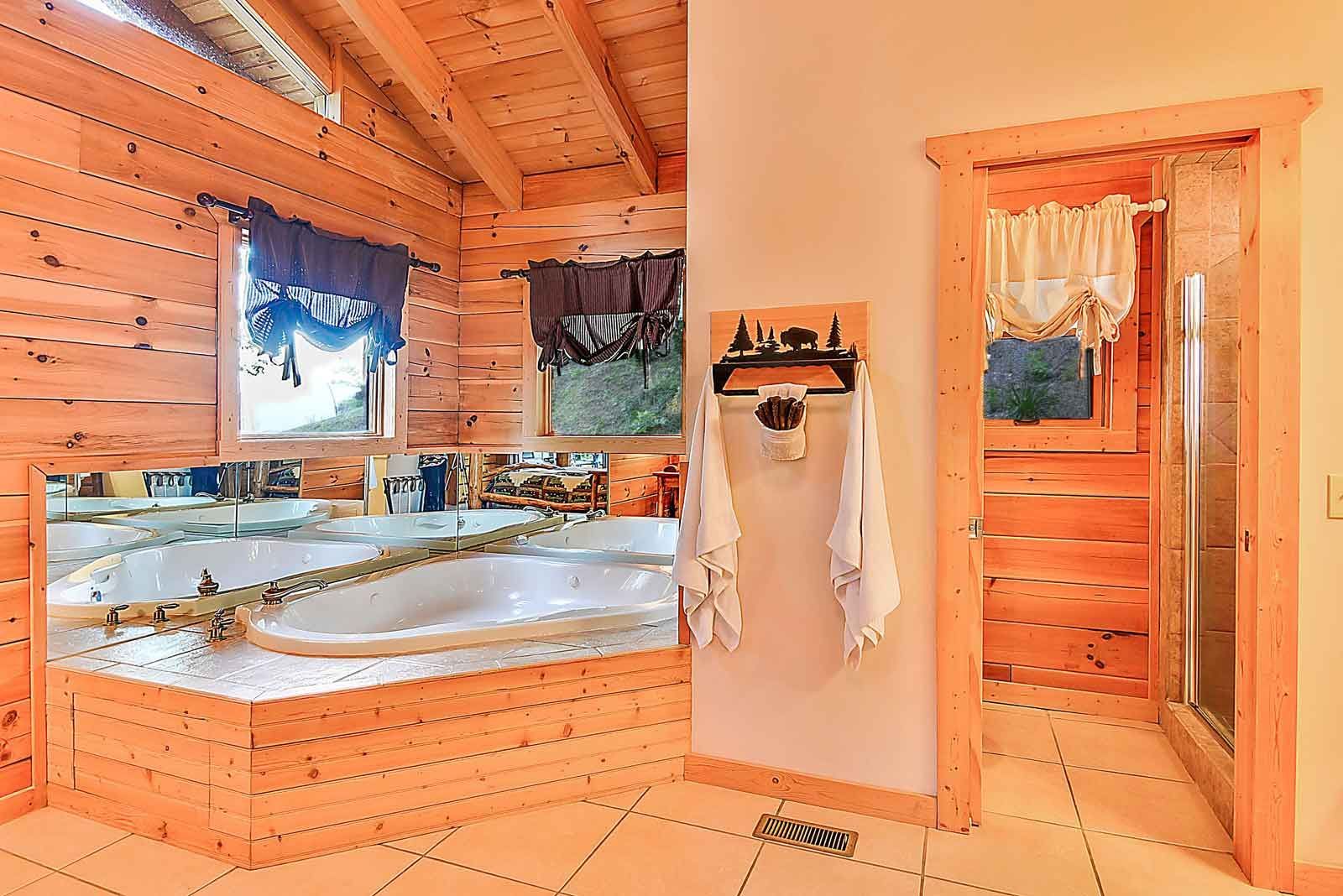Wooden bathroom with a large tub, towels, and a shower.