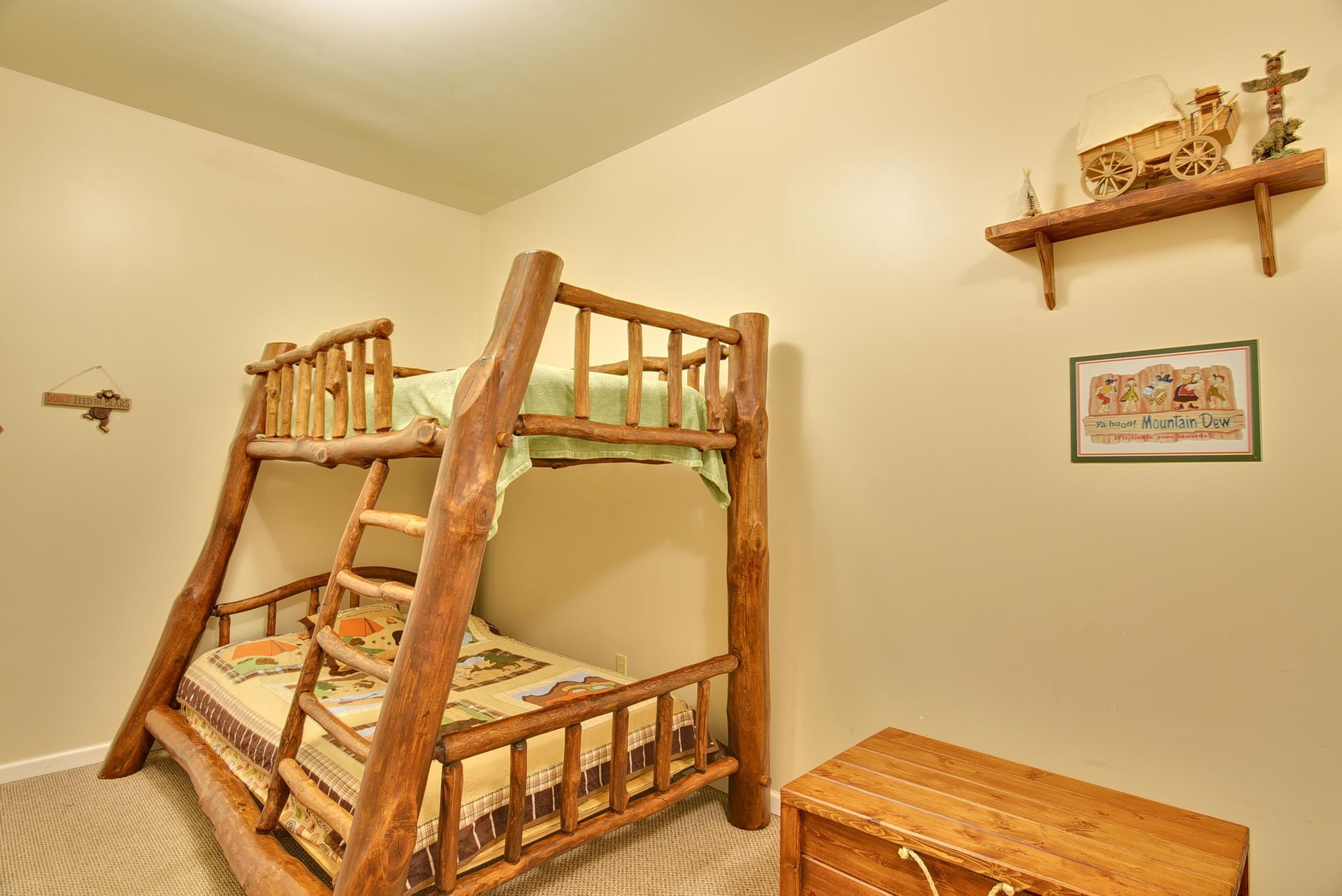 Bunk beds with rustic wood frame in a beige room; a wooden chest is in the corner.