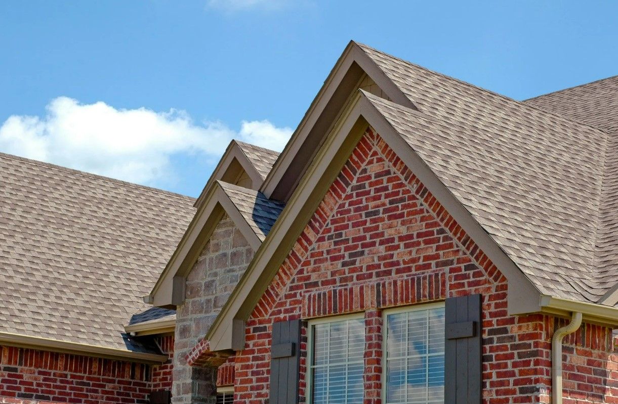 A brick house with a brown roof and a window