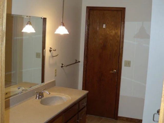 A bathroom with a sink a mirror and a door