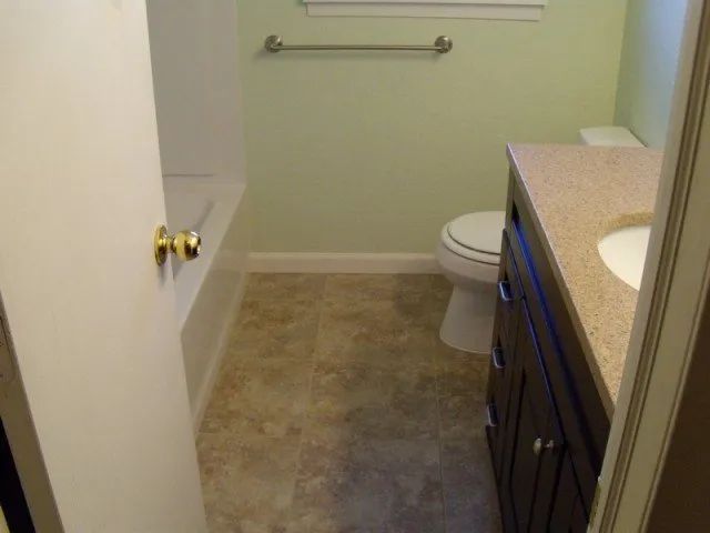 A bathroom with a toilet , sink and bathtub