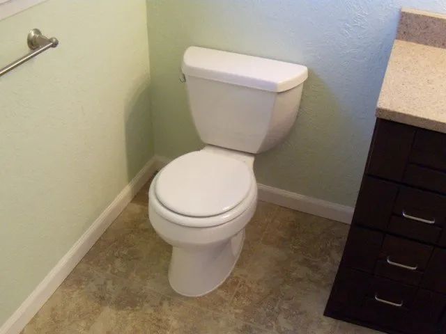 A toilet in a bathroom next to a sink