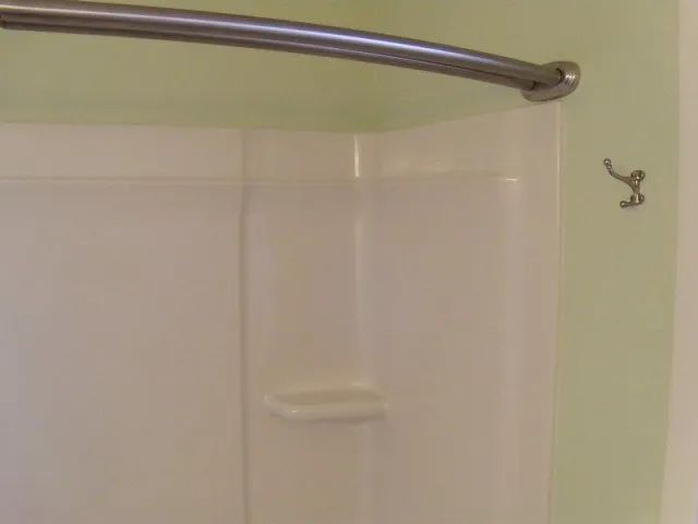 A shower curtain is hanging from the ceiling in a bathroom