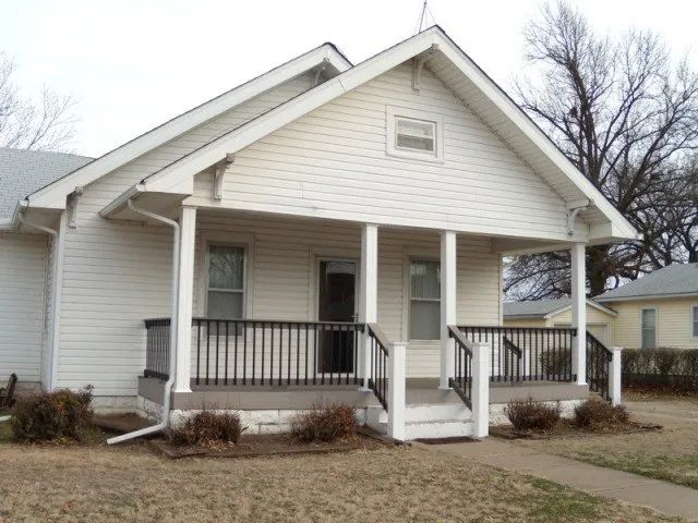 A white house with a porch and stairs