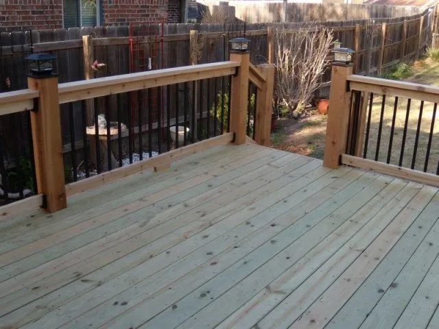 A wooden deck with a fence in the background
