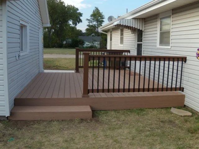 A white house with a brown deck in front of it
