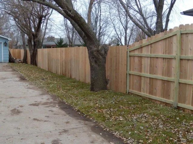 A wooden fence along the side of a road